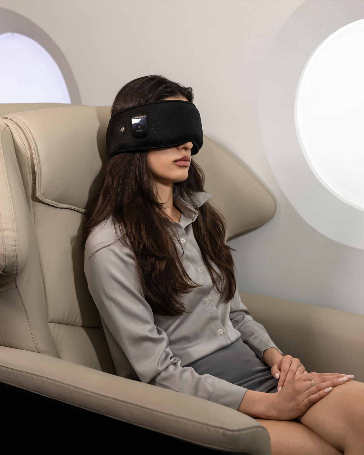 Traveler resting on a long flight wearing a Hypnuse sleep mask