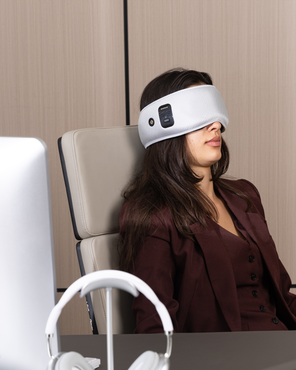 Person taking a short power nap at work with a Hypnuse sleep mask